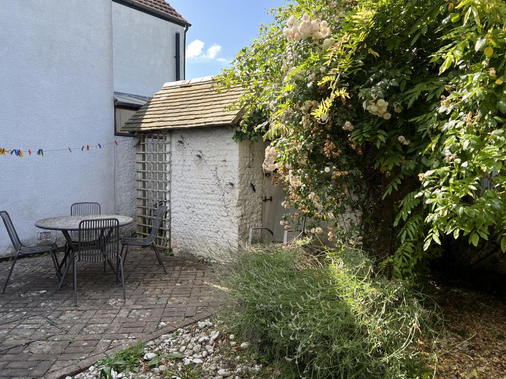 Lot: 138 - TWO-BEDROOM THATCHED COTTAGE FOR OCCUPATION OR INVESTMENT - View of patio area in garden
